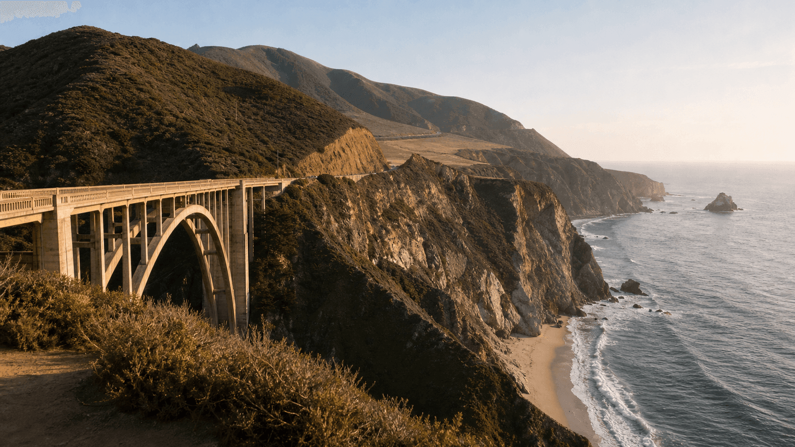 Concrete arch bridge spanning a narrow coastal ravine