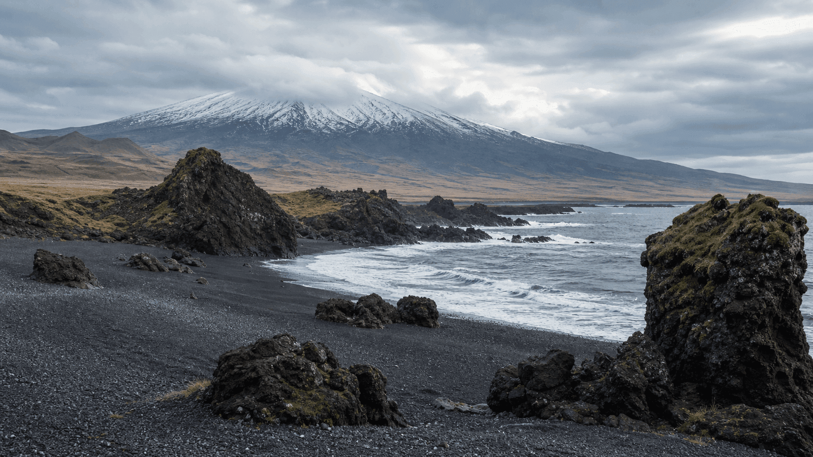 Dark pebble beach and volcanic landscape