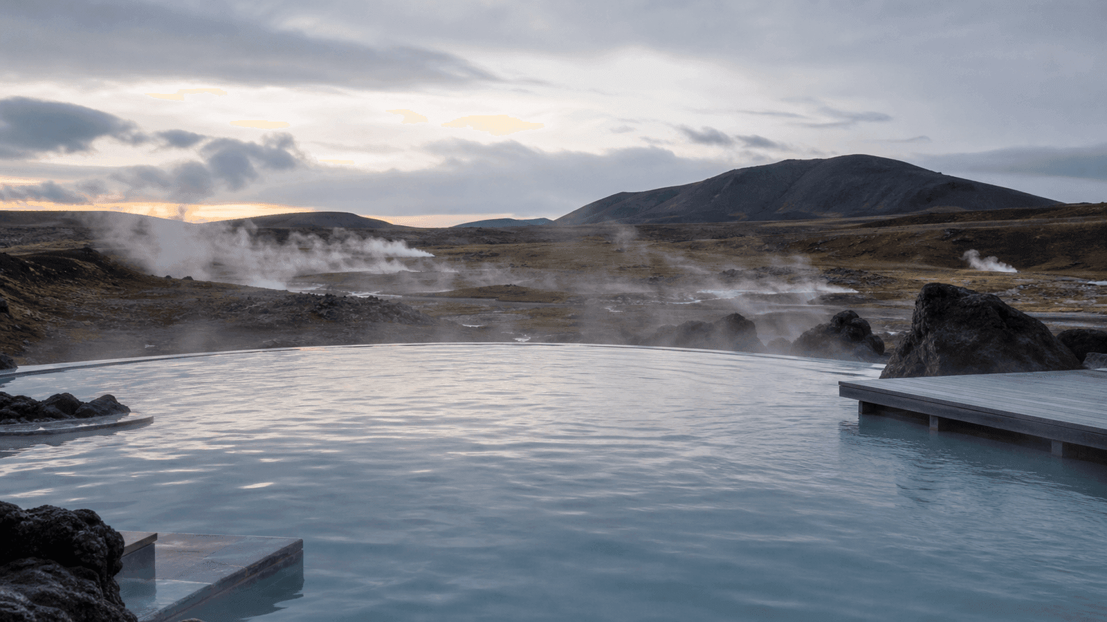 Steaming pale-blue pool beside a deck