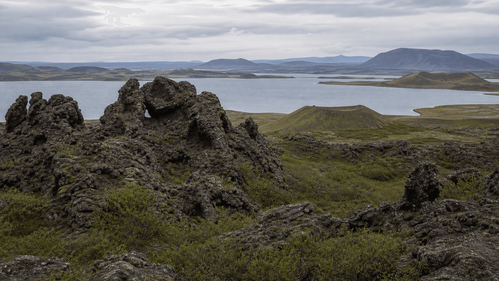 Dark lava formations beside a lake