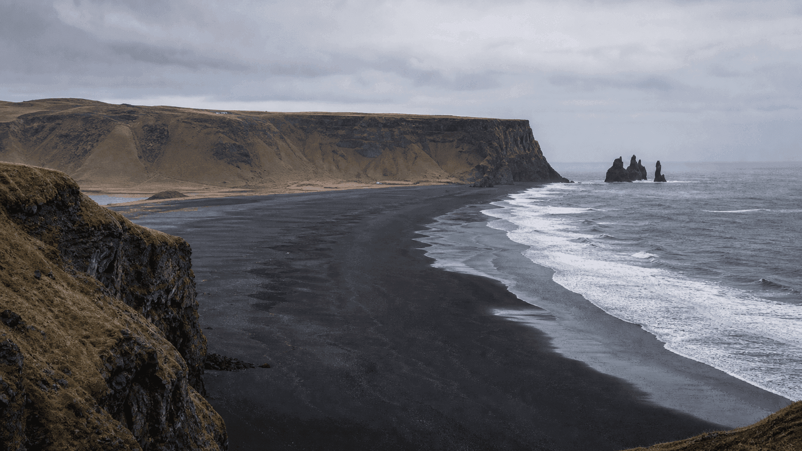 Black beach, sea stacks and cliffs in a composite scene