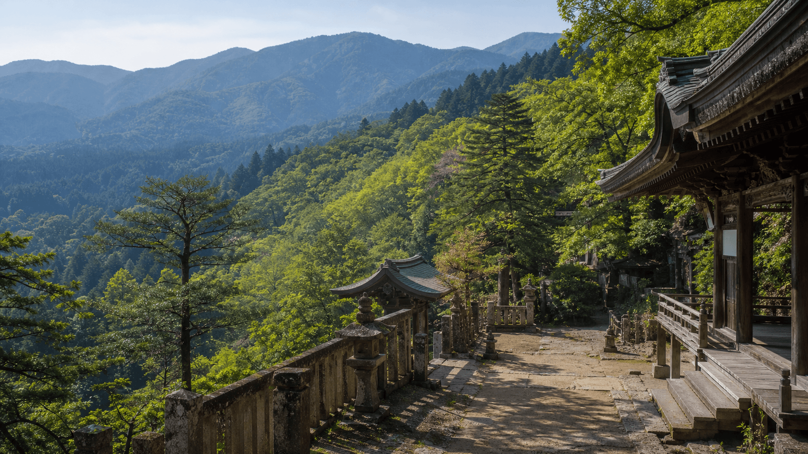 Wooden temple building on a forested mountainside beside a stone path and lanterns