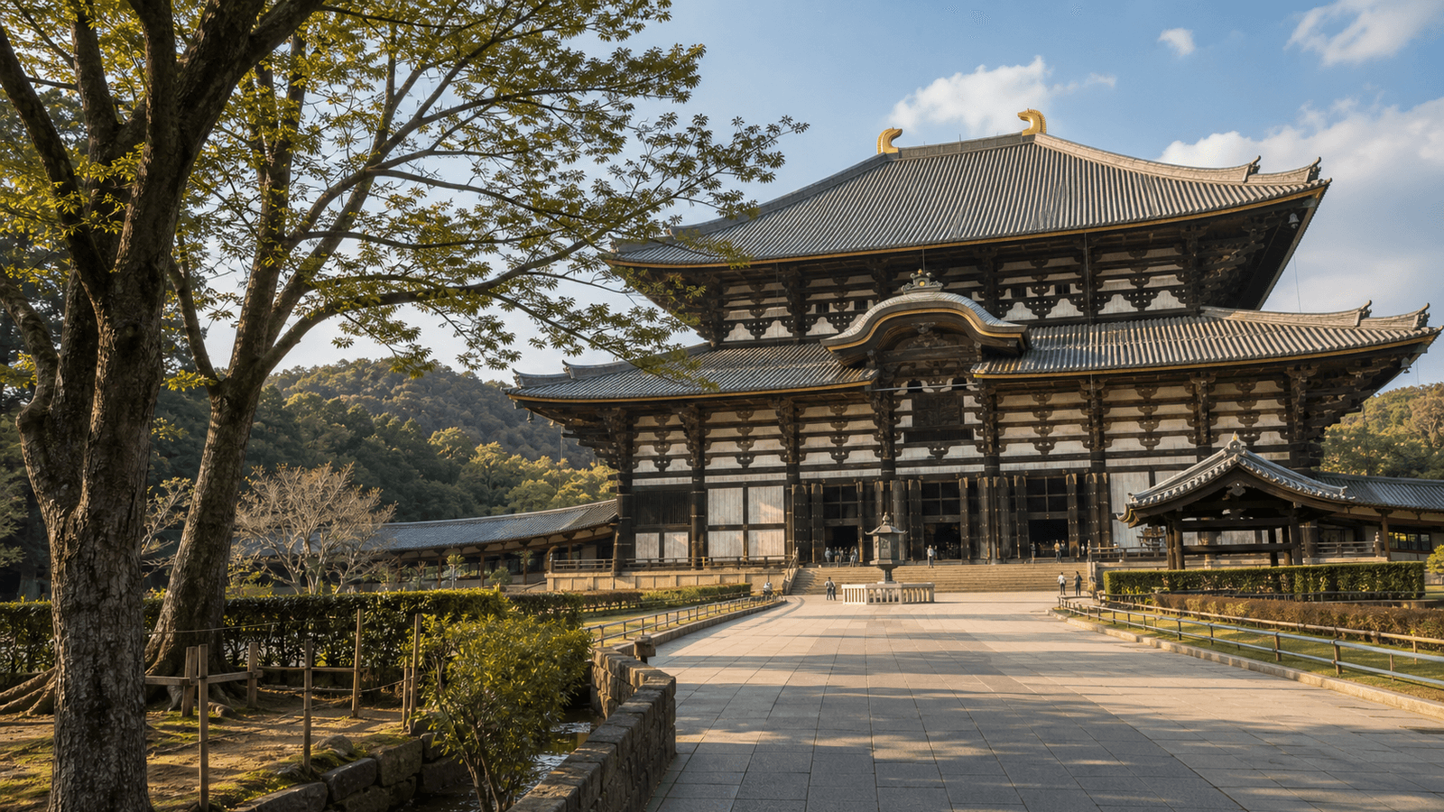 Broad paved approach to a large wooden temple hall with a two-tiered roof