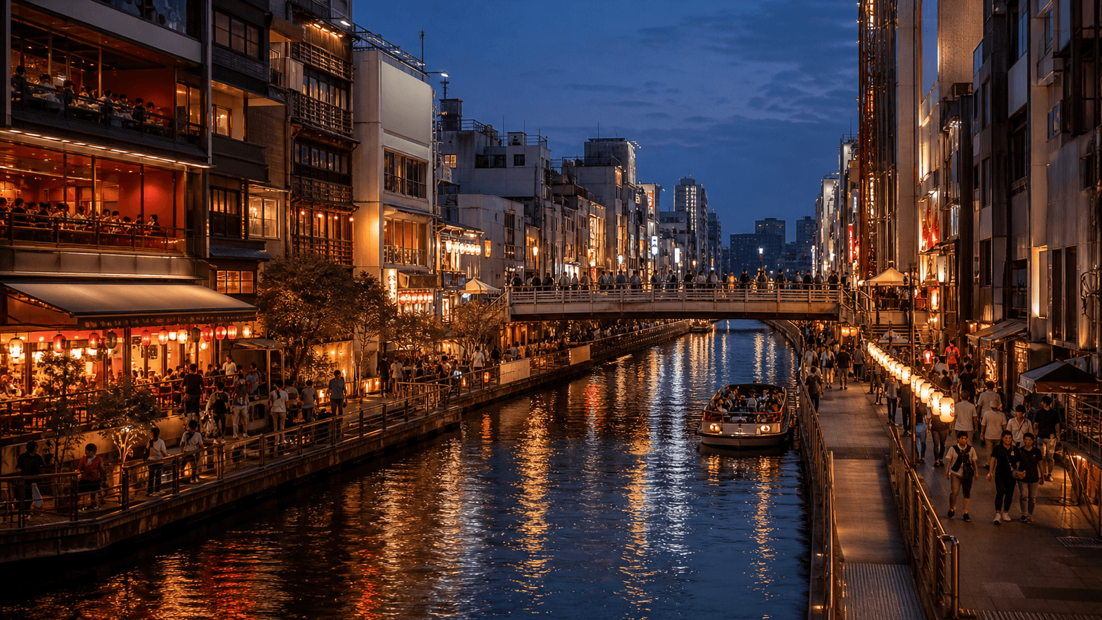 Canal with a sightseeing boat, footbridge and brightly lit restaurants on both banks