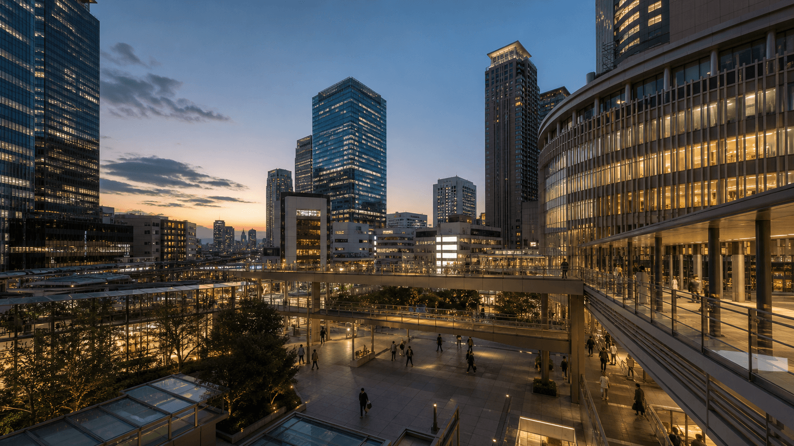 Modern high-rise buildings above a plaza with walkways on several levels in the evening light