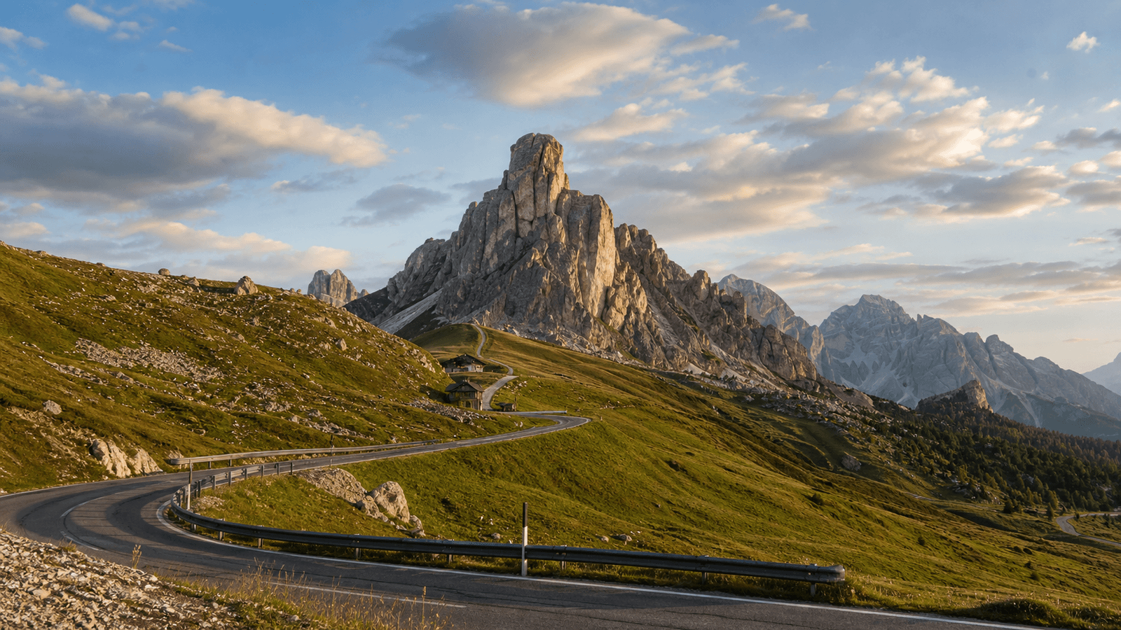 Winding mountain pass road and prominent rock tower.