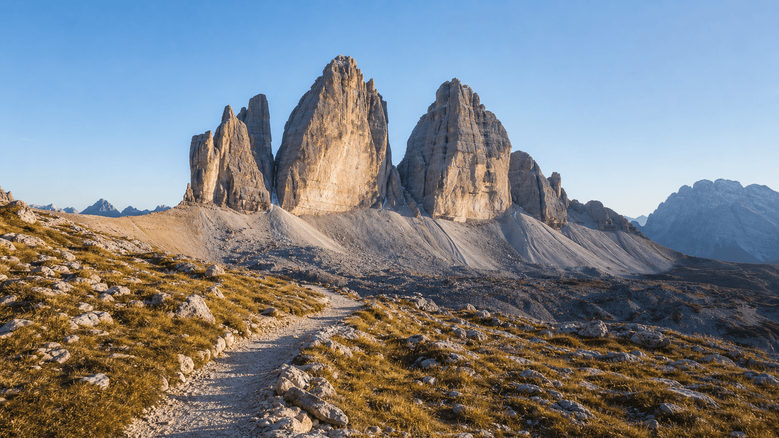 Rocky path beneath three prominent mountain towers.