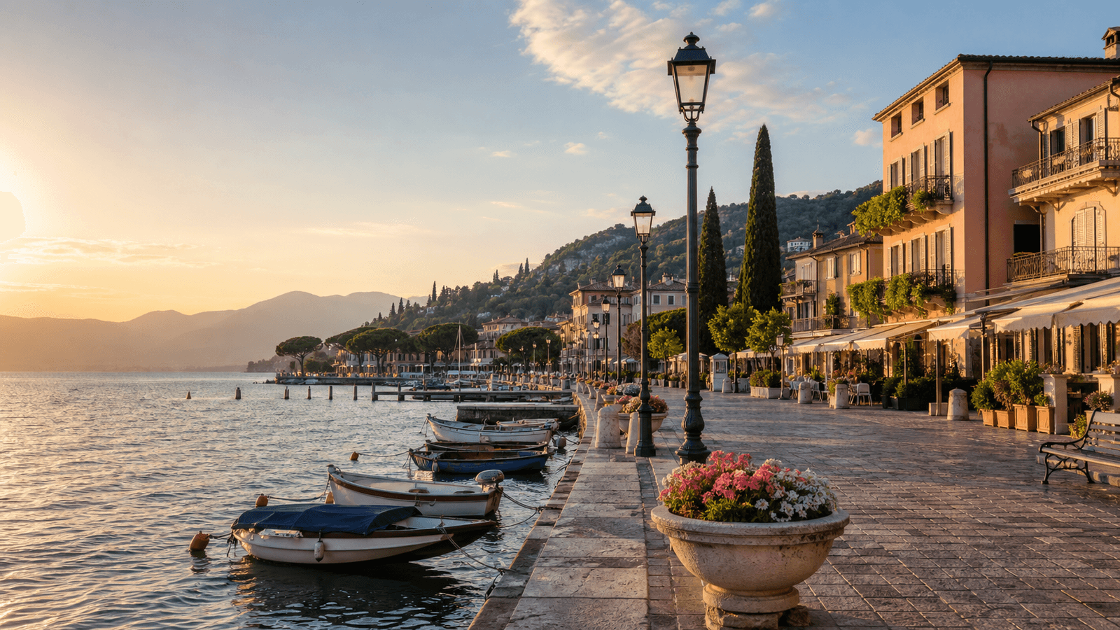 Boats and sunlit buildings along a lakeside promenade.
