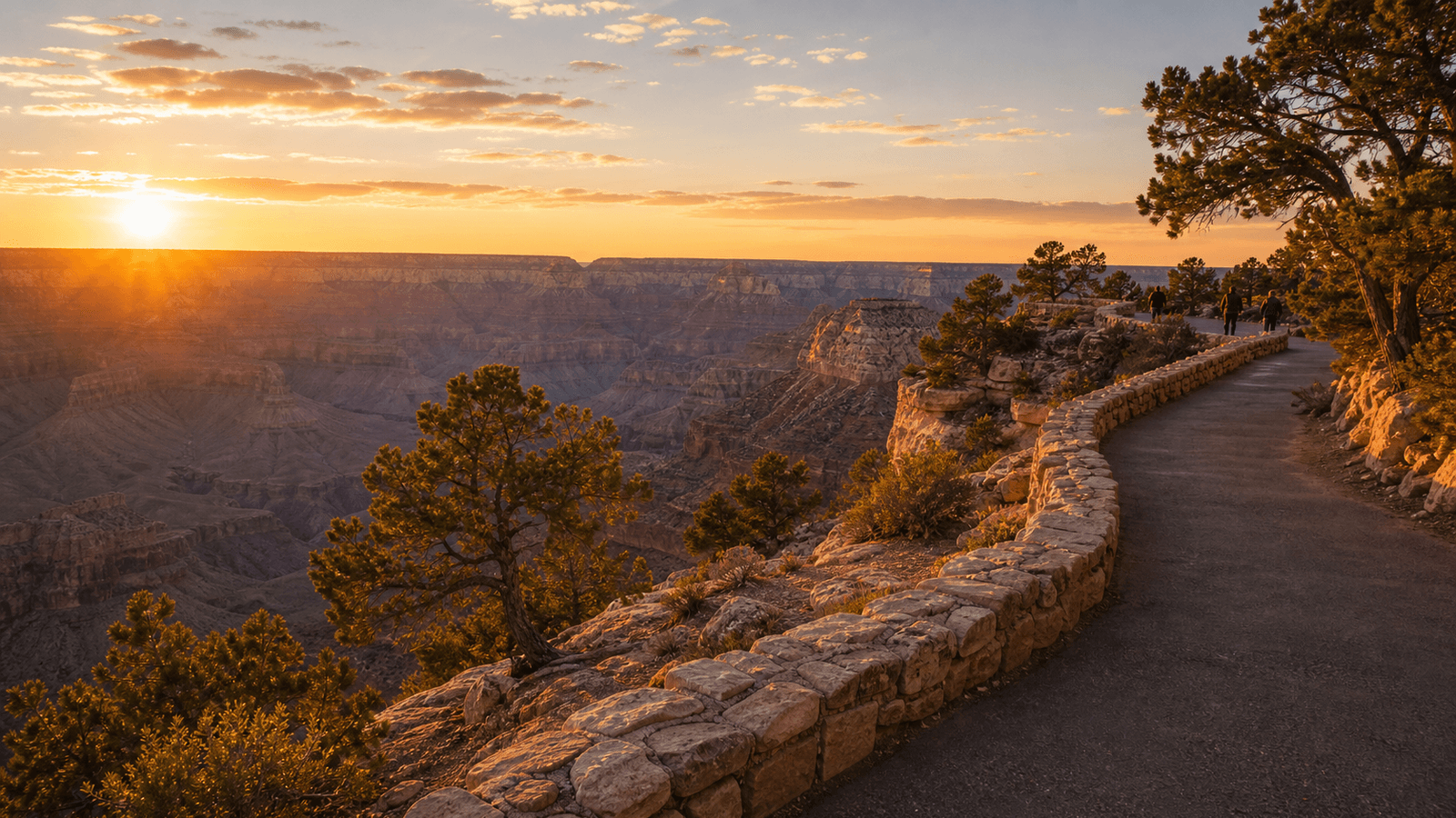 Paved rim path with a stone wall above the canyon
