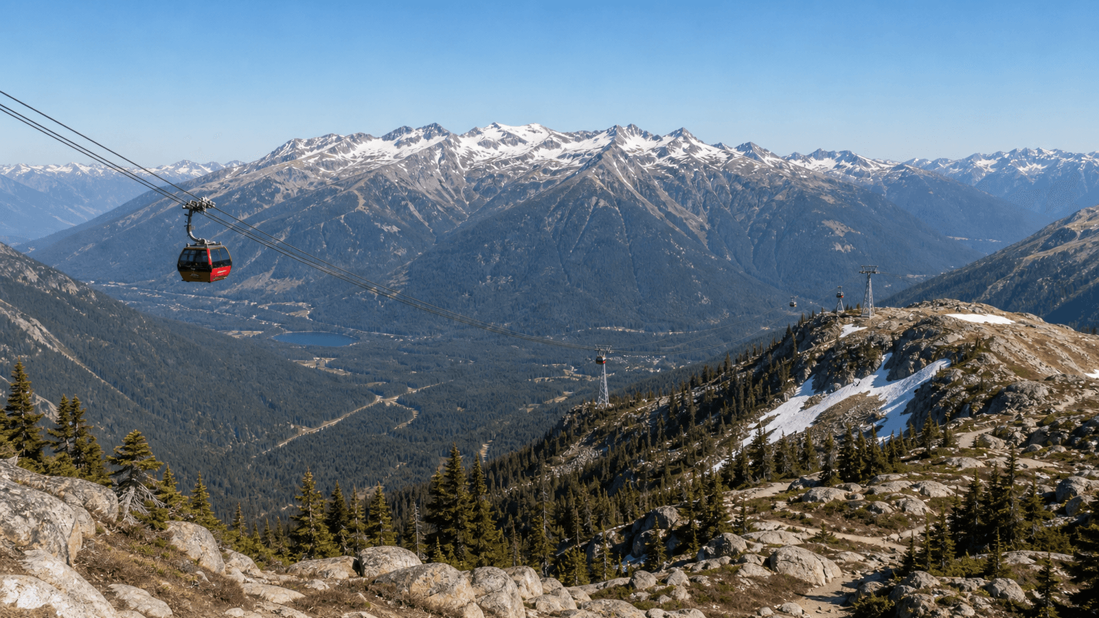 Red gondola above a wooded valley and high mountains